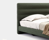 Customisable designer bed for high-end home decor, featuring elegant wooden legs and premium upholstery.