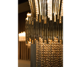 Luminous Masterpiece: The Scala Chandelier, a captivating spectacle of light, featuring gold-plated brass and cascading teak crystals that transform any space.