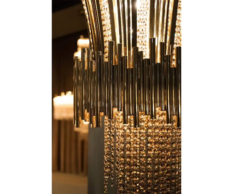 Luminous Masterpiece: The Scala Chandelier, a captivating spectacle of light, featuring gold-plated brass and cascading teak crystals that transform any space.