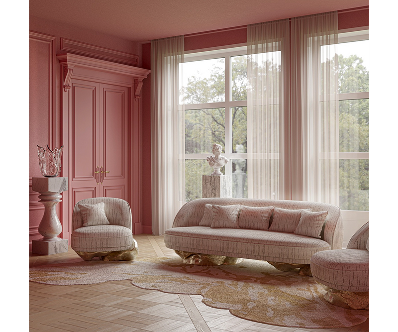 A stunning living room interior in a soft, blush pink hue. The room features a plush, curved sofa and armchair upholstered in a neutral fabric with a hint of gold.