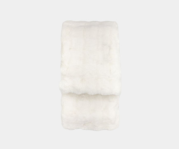 Indulge in the Cloud Cuddle Throw. This luxurious faux fur throw, featuring a creamy white hue and a rabbit fur blend texture, adds a touch of opulence to any home decor.