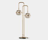 Illuminate Your Living Room with the Miles Modern Floor Lamp.  Bathe your living room in a warm, sophisticated glow with the Miles floor lamp by Mezzo Collection. This modern masterpiece features a gleaming gold-plated brass frame and hand-blown glass globes, creating a captivating focal point that embodies the legacy of Miles Davis.