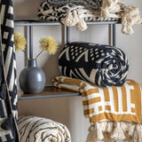 Cosy Comfort Meets Modern Style: Ochre & Cream Knit Throw with Tassels. Sink into pure comfort with this ochre and cream knit throw featuring charming cream tassels. Perfect for adding a touch of warmth and contemporary style to your bedroom.