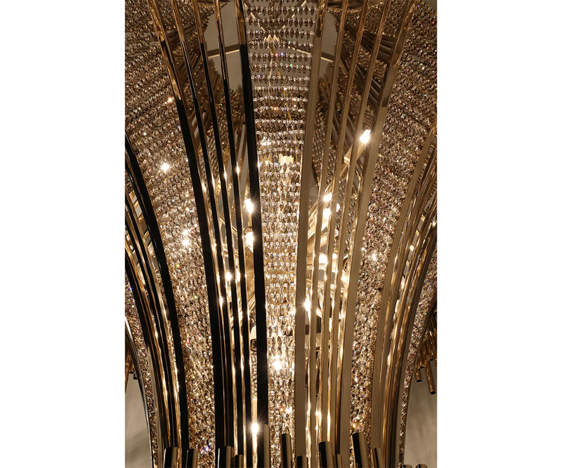 Statement Chandelier for Hospitality or Residential Lighting: The Scala Chandelier, a showstopping focal point with gold-plated brass and luminous teak crystals, ideal for hospitality projects and elegant homes.