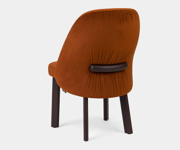 Cintura dining chair side profile highlighting its sophisticated curves and high-end aesthetic.